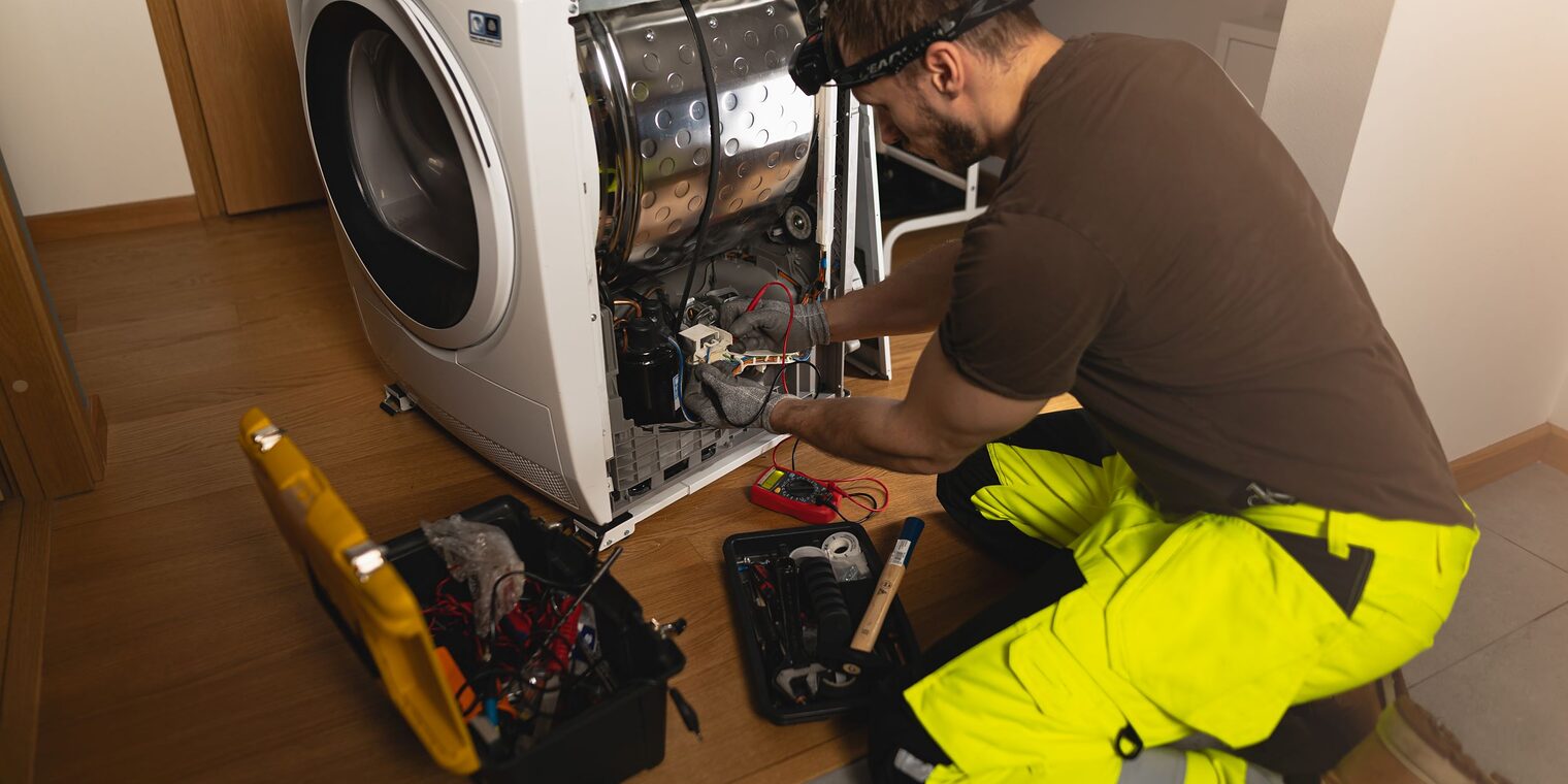 Handwerker repariert Waschmaschine